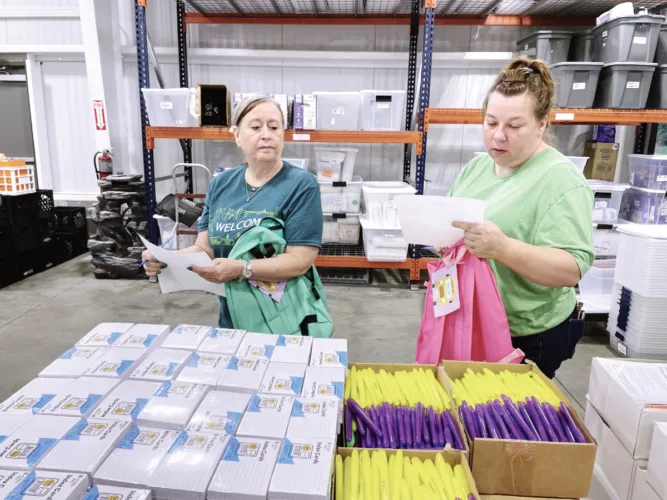 Volunteers pack school supplies